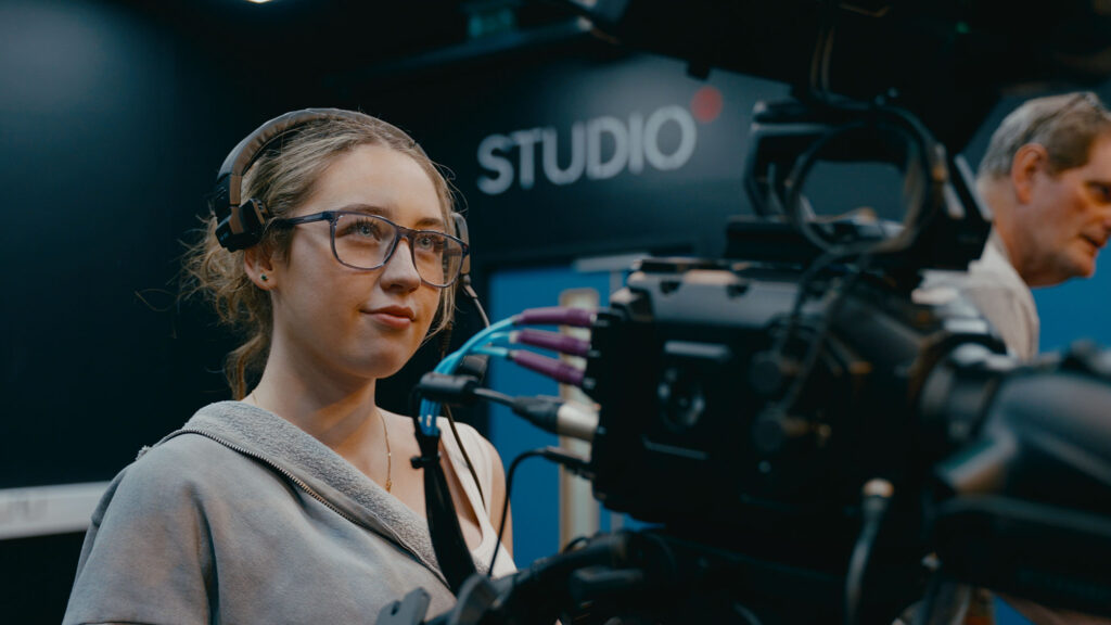 Student operating a television studio camera.