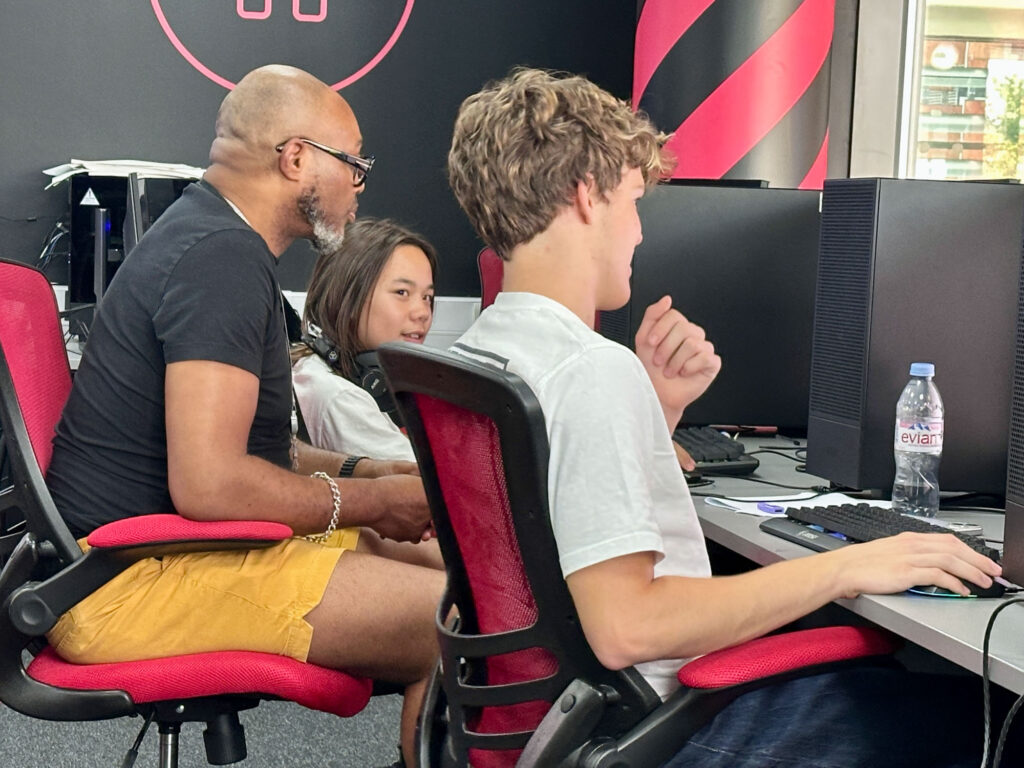 Worldbuilder student sitting in front of computers with tutor.