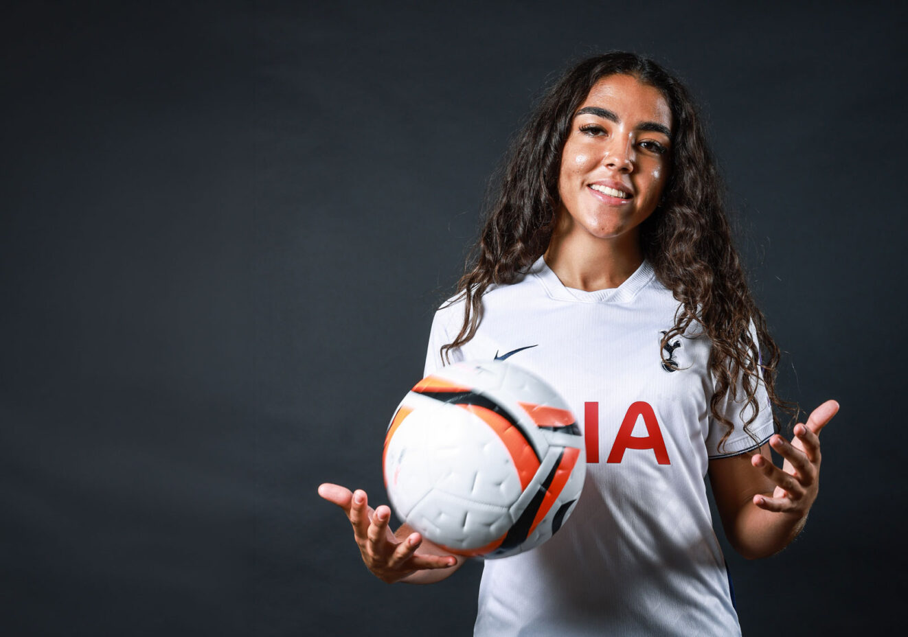 Women's football player with football.