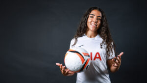Women's football player with football.